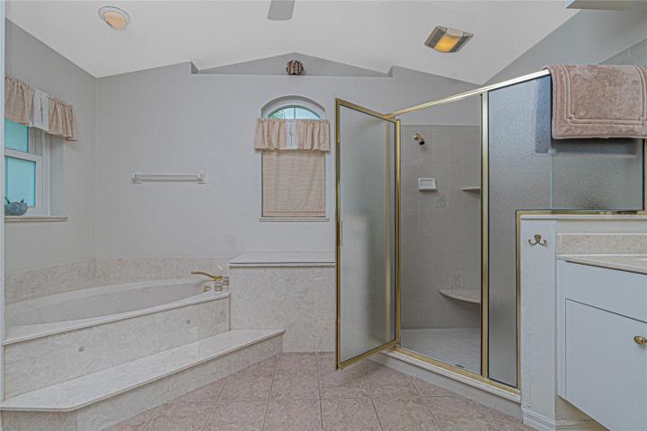 The master bath shower has tiled flooring and glass door.