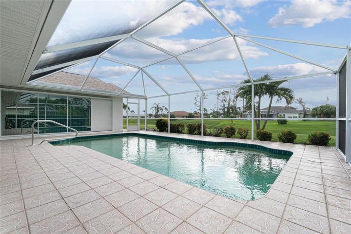The heated pool is surrounded by tiled flooring and looks out to the freshwater canal.