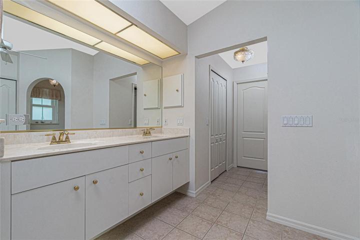 The master bathroom has under-vanity lighting, tile flooring and two walk-in closets.