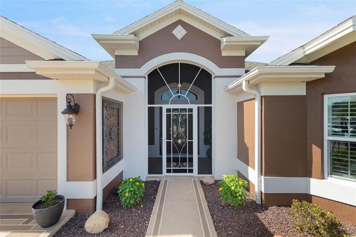 THIS GRAND ENTRANCE HAS A SCREENED ENCLOSURE AND A BEAUTIFUL LEADED-GLASS DOOR LEADING INTO THE HOME...