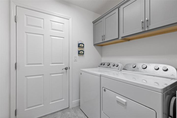 LAUNDRY LEADING TO GARAGE... PLENTY OF CABINET SPACE FOR EVEN MORE STORAGE