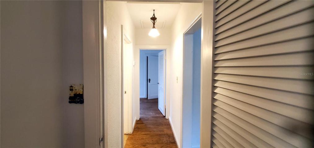 Hallway between 2 bedrooms & bathroom. Living room doorway on right.