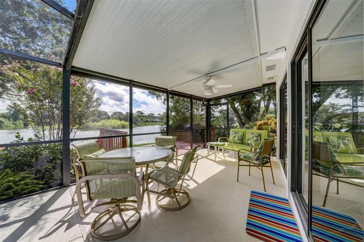 Screened-in outdoor dining/sitting area has stunning views of the lake, deck and landscaping.