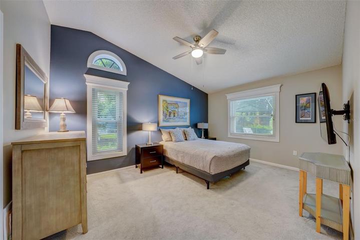 The primary bedroom offers vaulted ceilings, walk-in closet, an enviable lake view, and an en-suitebathroom