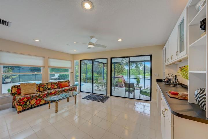 The sunroom features large windows overlooking the pool area and two setsof glass sliders that offer scenic views of the lake