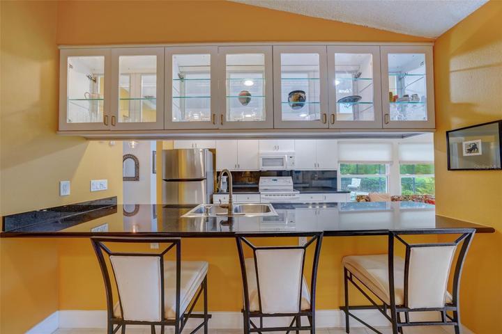 Breakfast bar looking in toward kitchen with display cabinets above.