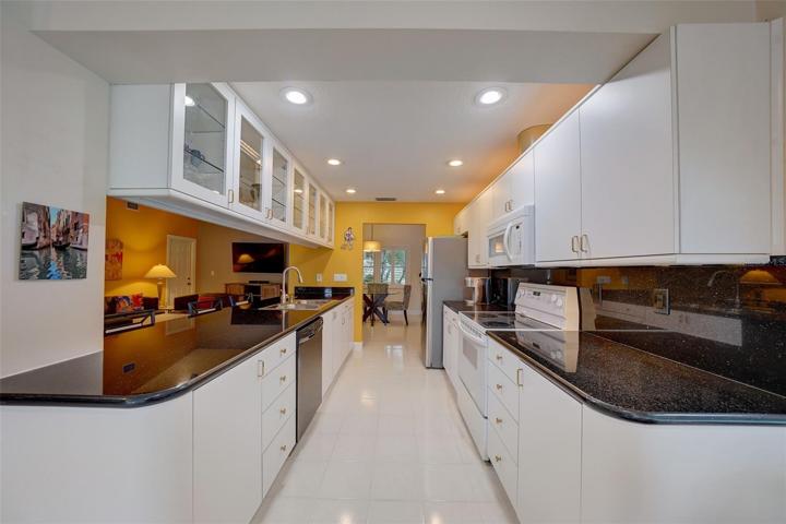 Black and white galley-style kitchen looking toward eating area.