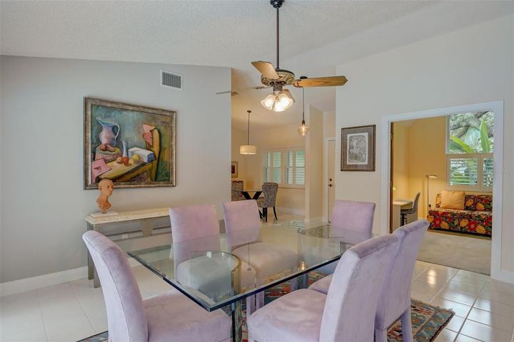 The dining room, or what could also serve as a living room, has a wall of windows that frame the beautiful outside scenery and French doors leading out to the pool area