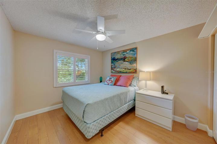 The third bedroom has a lake view, laminate flooring, and plantation shutters.