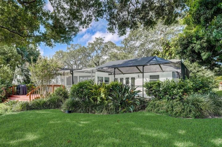 The well-manicured mature landscaping adds to the curb appeal and creates a serene tropical sanctuary in the back yard