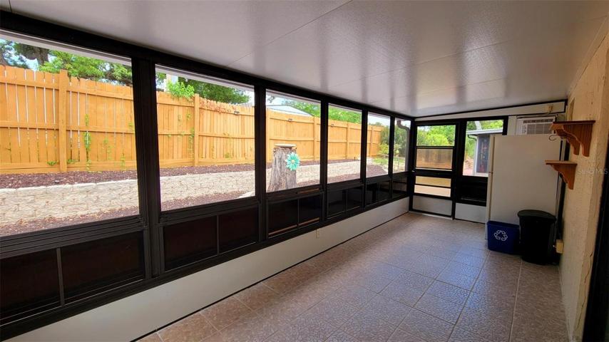 Large lanai with soft vinyl windows (screened) & window AC unit.