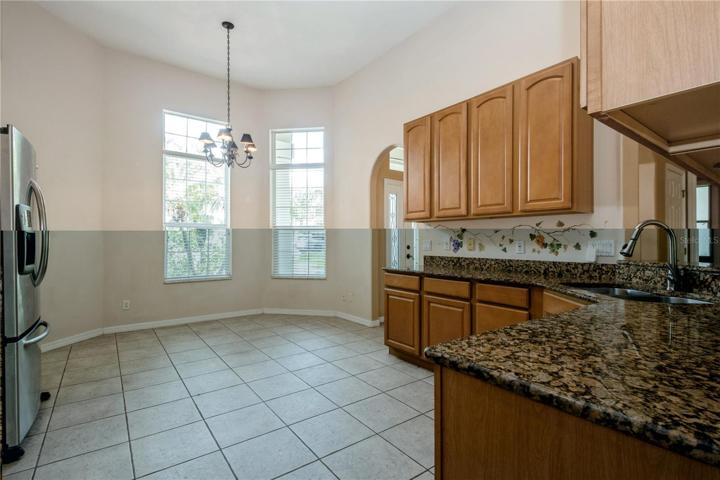 View of eat in kitchen. Tile kitchen floor, granite counter tops, wood cabinets.