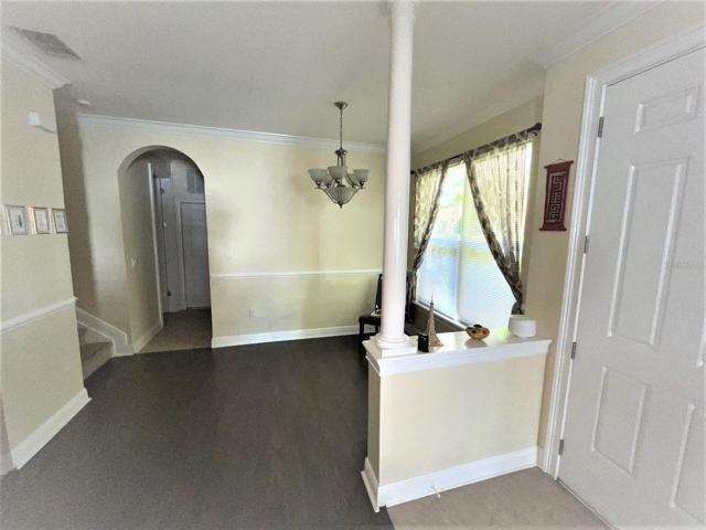 Dining area just to the right of the entrance door - stairs to the left lead to upstairs bedrooms/bathrooms. Door to garage is straight ahead through the arched doorway..