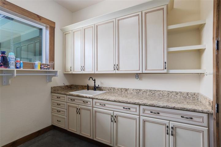 Laundry room with utility sink and counter space.