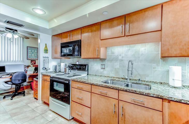 Kitchen area with recessed and under cabinet lighting.