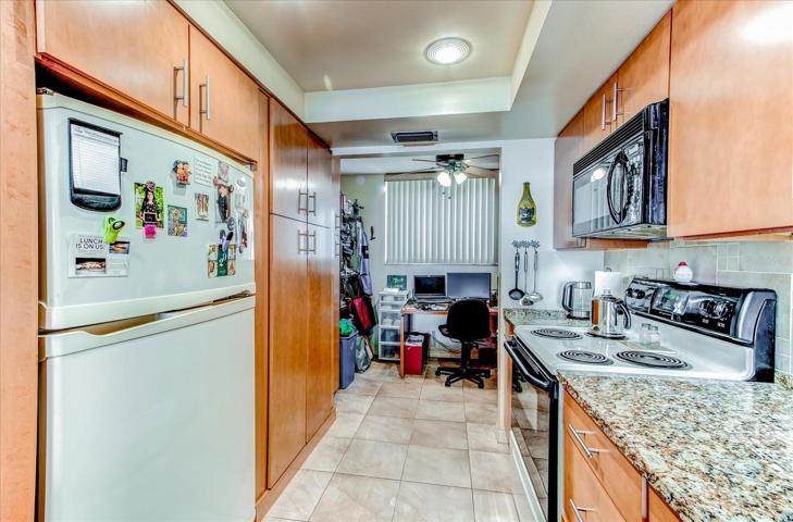 Kitchen with view of additional room in back.