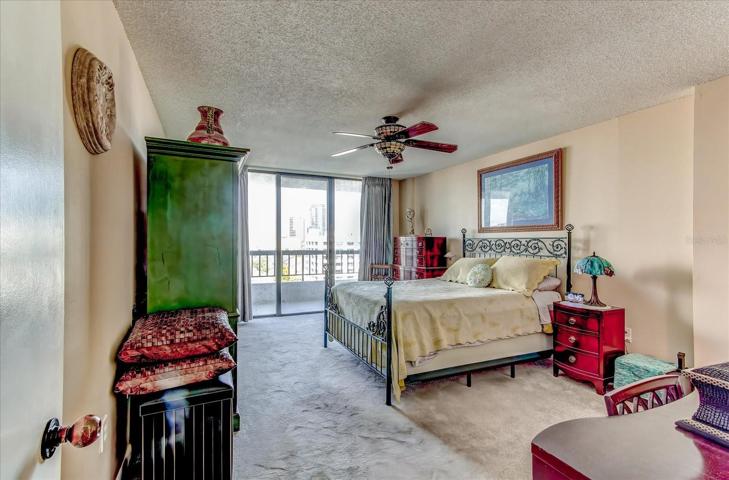 Primary bedroom with sliding doors leading to balcony and view of Lake Eola.