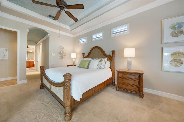 Oversized Master Bedroom Suite with Tray Ceilings, Crown Molding, and Plantation Shutters. Also has access to the Pool and Lanai.