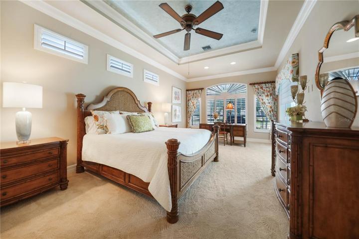 Oversized Master Bedroom Suite with Tray Ceilings, Crown Molding, and Plantation Shutters. Also has access to the Pool and Lanai.