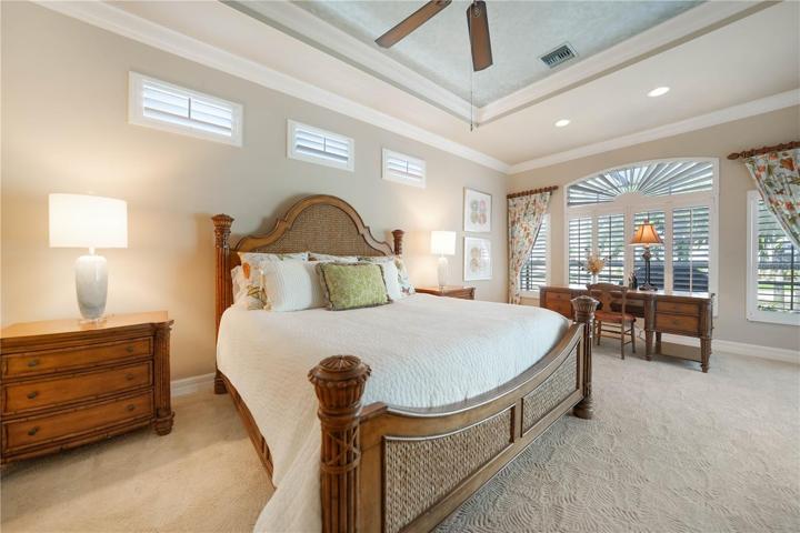 Oversized Master Bedroom Suite with Tray Ceilings, Crown Molding, and Plantation Shutters. Also has access to the Pool and Lanai.