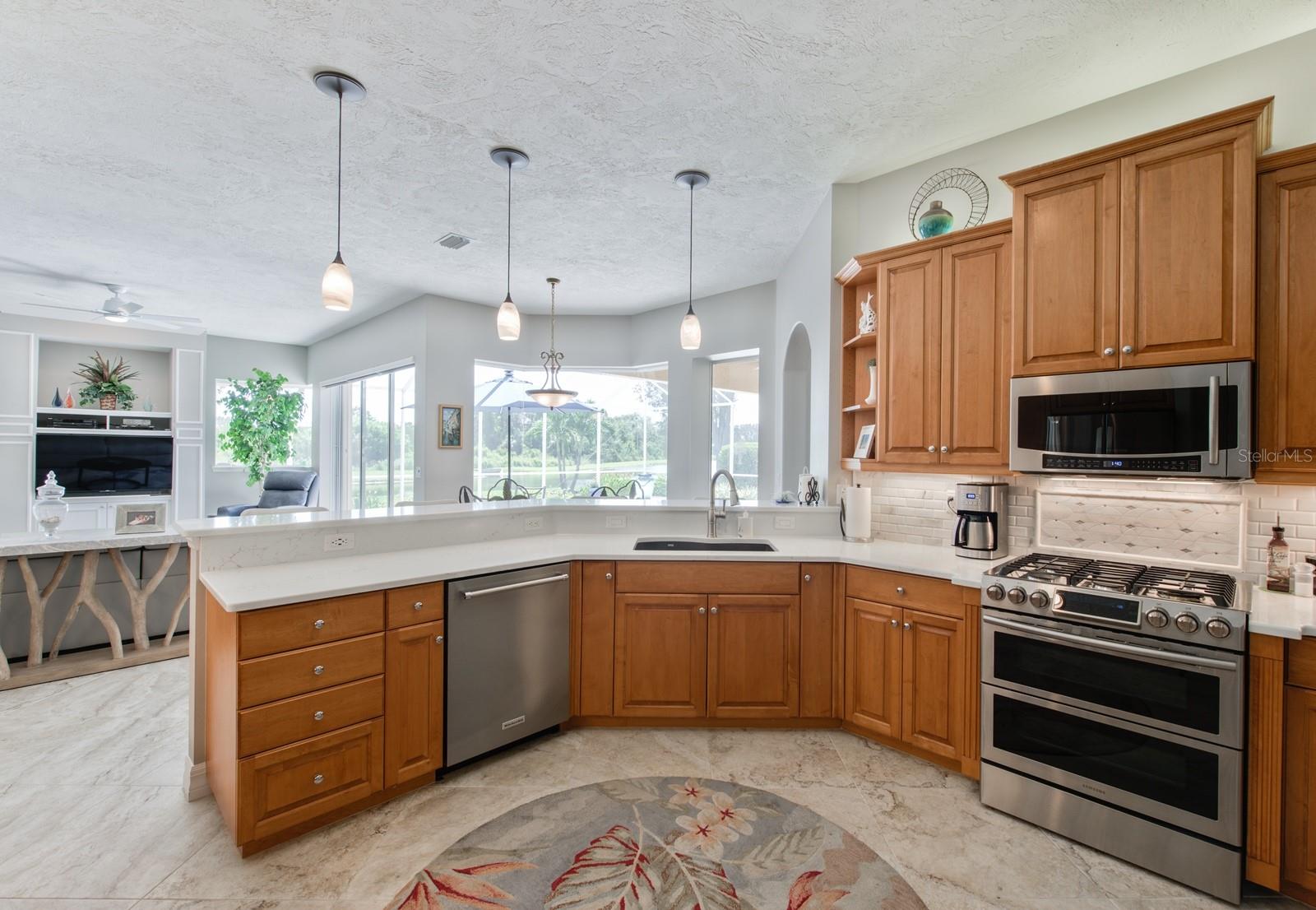 Fingerprint resistant stainless appliances and beautiful tile backsplashes complete the kitchen. A large deep sink and quiet Kitchen Aide dishwasher make for easy clean up.