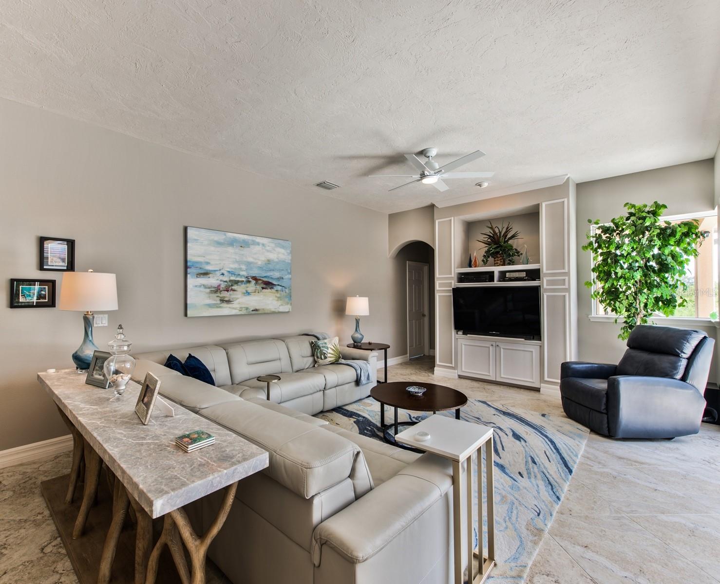 High ceilings in the family room enhance the space which features built in shelving &amp; cabinets and its own portrait window for added lake and preserve views.