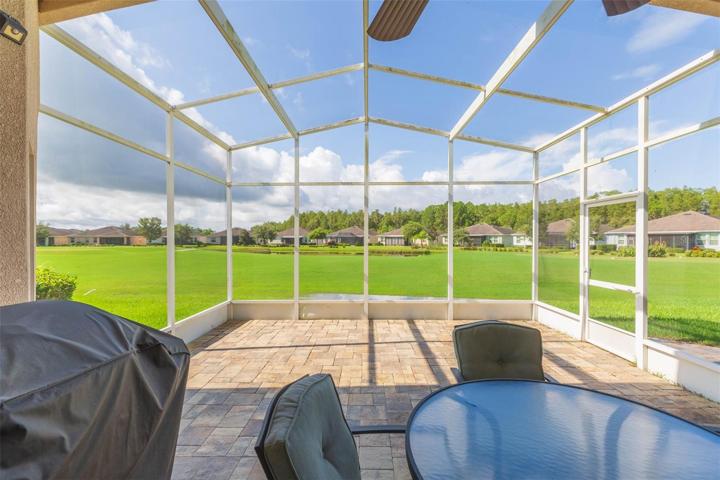 Large pavered lanai with golf course and pond view
