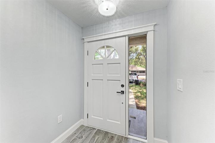 New Solid wood front door with a window to allow for more natural light.