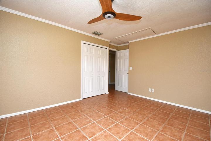Crown molding, a modern ceiling fan, a built in closet and ceramic tile flooring round out the master.