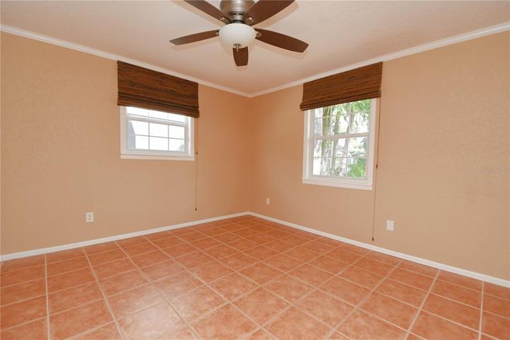 bedroom 2 features ceramic tile flooring, window blinds, a ceiling fan and built in closet.