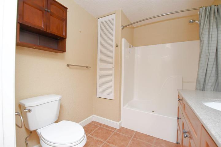 The bathroom features a linen closet and a wall hung cabinet.