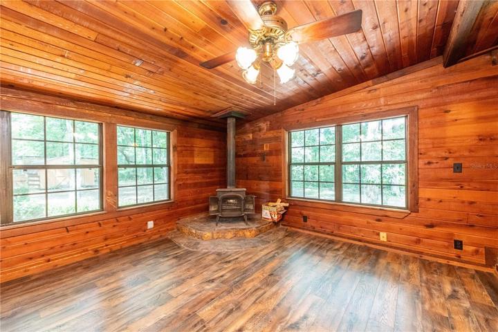 Living room with 2 ceiling fans and wood burning fireplace.