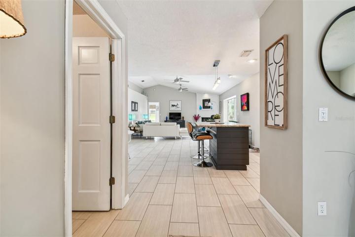 Entry way view to great room, laundry on left, dining to the right