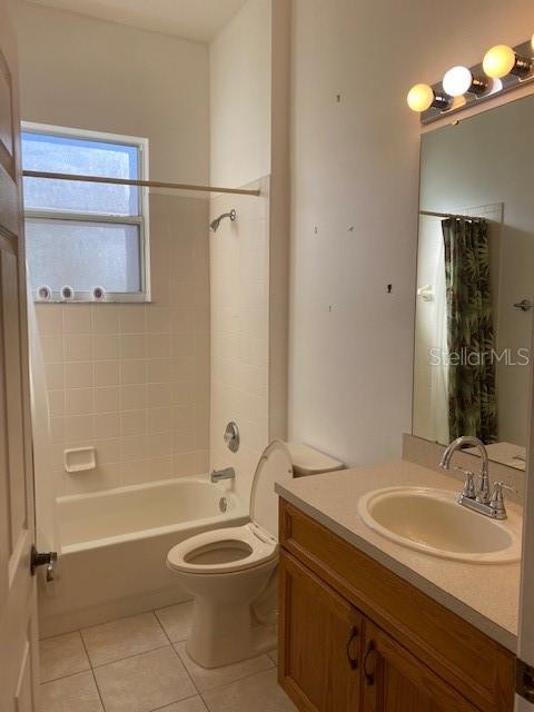 GUEST BATHROOM, TILE FLOORS AND TUB WITH SHOWER.
