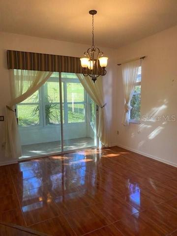 DINING ROOM WITH GORGEOUS TILE HARDWOOD FLOORS AND PATIO SLIDERS OUT TO LANAI.