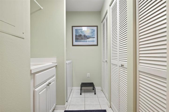 Laundry room with sink and closets for storage