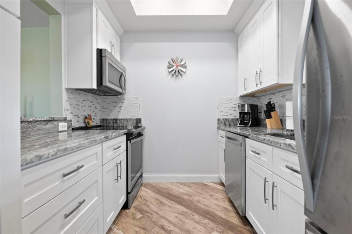 Kitchen with white Shaker cabinets, granite counters, ss appliances
