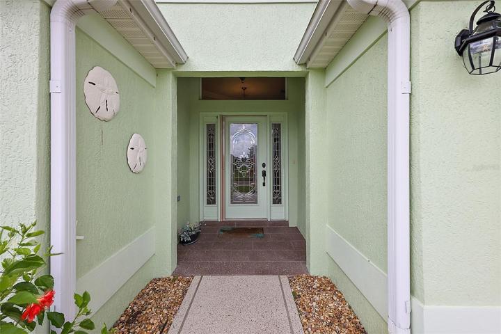 Covered front entrance w/elegant leaded glass door