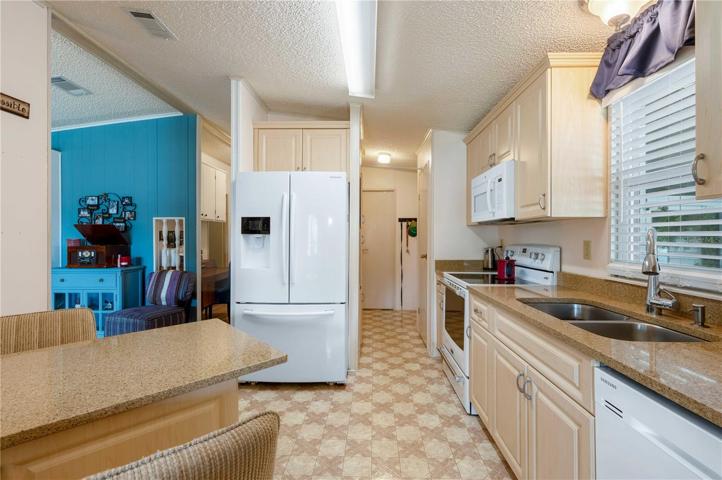 Kitchen has updated counter tops, plenty of storage, and newer appliances.
