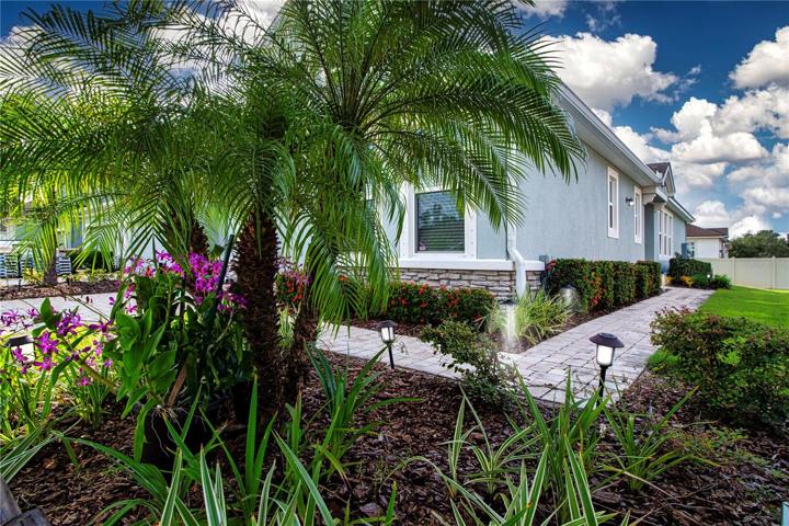 Beautiful lush tropical Florida Orchid and landscaping surrounds this Modern Townhome in Paradise