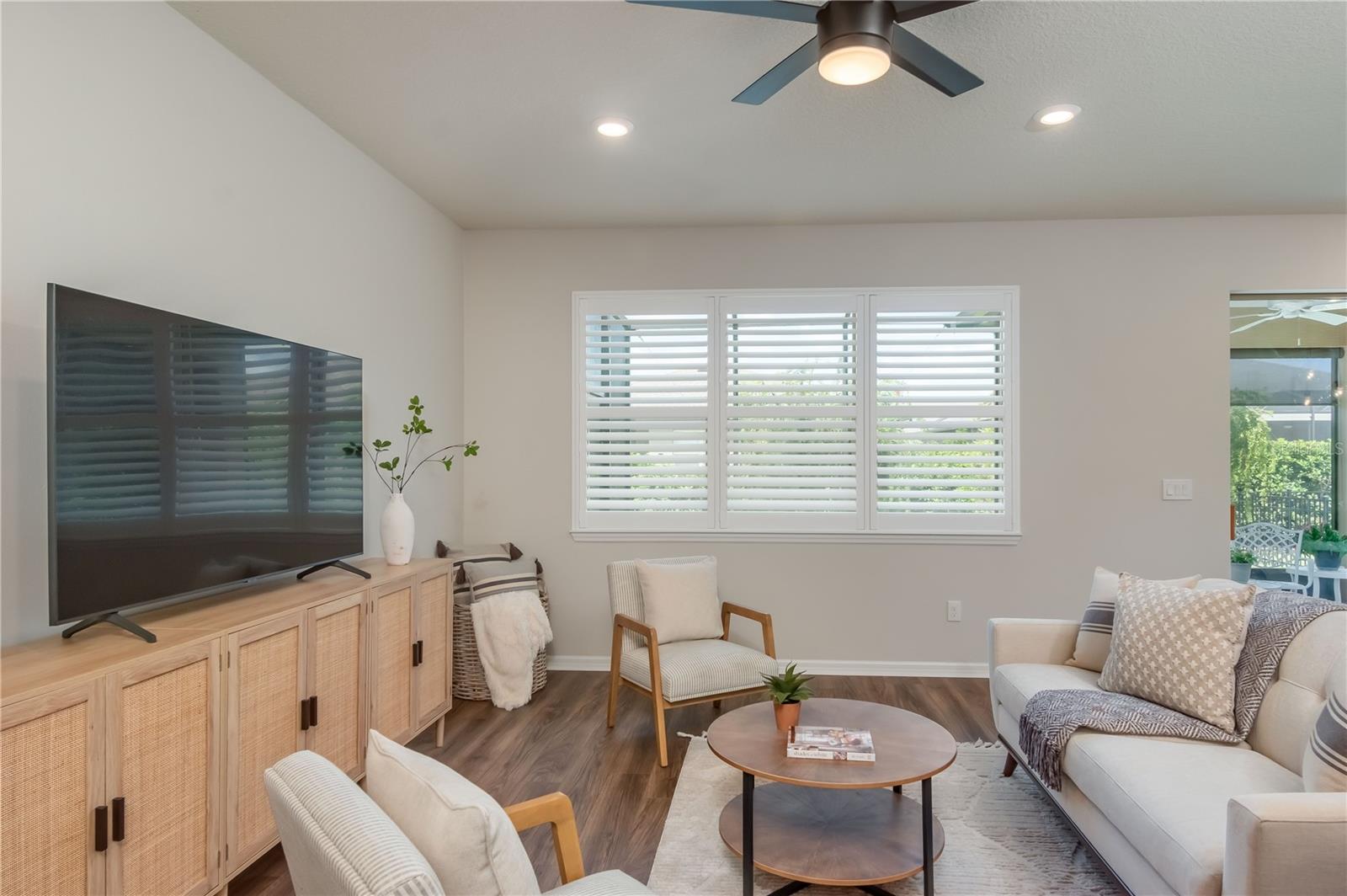 Large great room with LVP flooring and plantation shutters
