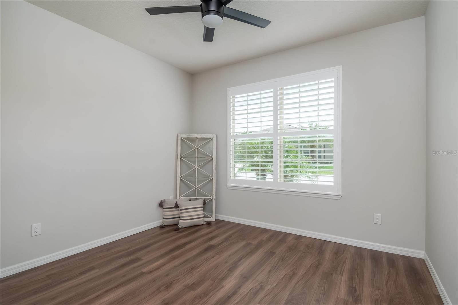Guest bedroom with new LVP floors, plantation shutters, large closet and new LED fan. Good size closet as well for storage.