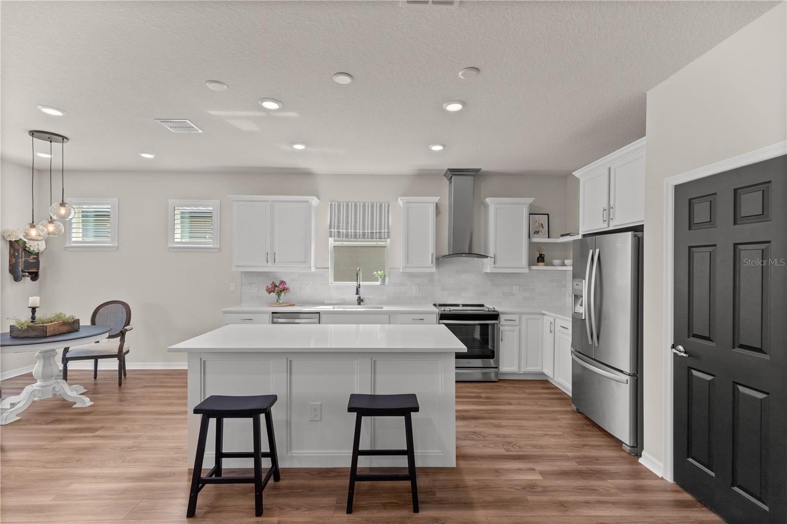 Newly updated kitchen - quartz counters, Bedrosians Cloe tile backsplash, Z-Line range hood, custom island surround, custom open shelving and more!