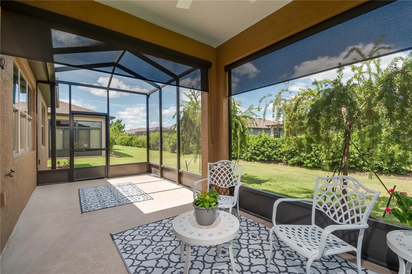 Extended screened lanai with large birdcage and custom shade screens.