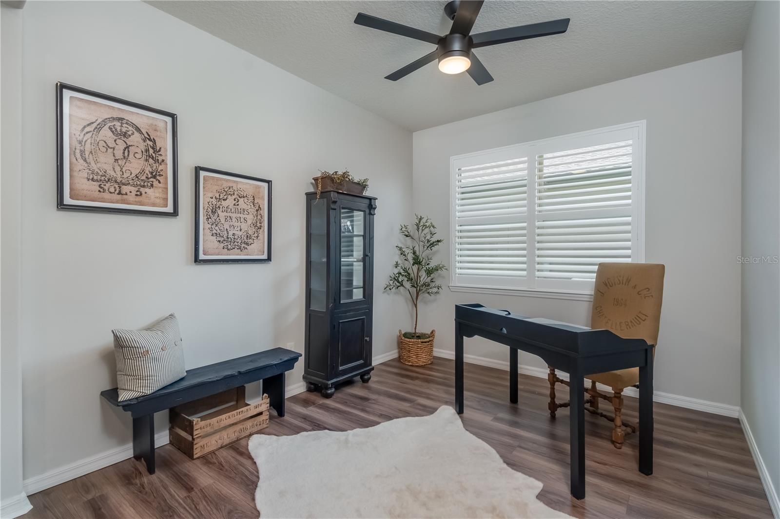 Large flex room with LVP and plantation shutters. Perfect for home office.