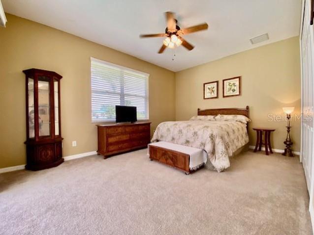 Oversized guest bedroom with sliding glass doors and a water & pool view