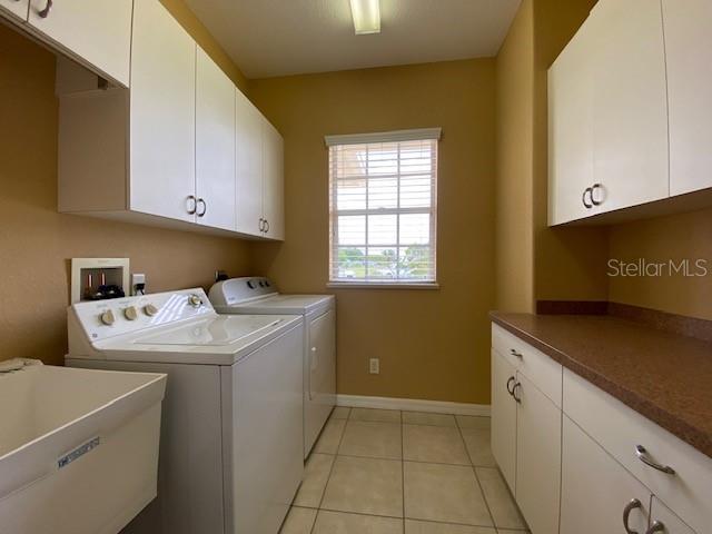 Laundry room off the kitchen with utility sink & and cabinets galore