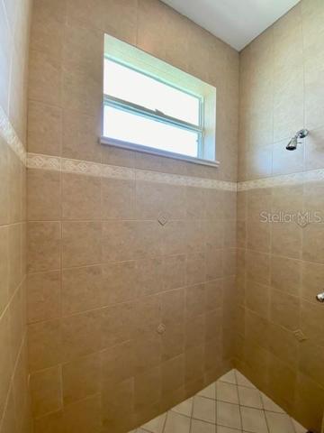 Floor to ceiling ceramic tiled guest shower