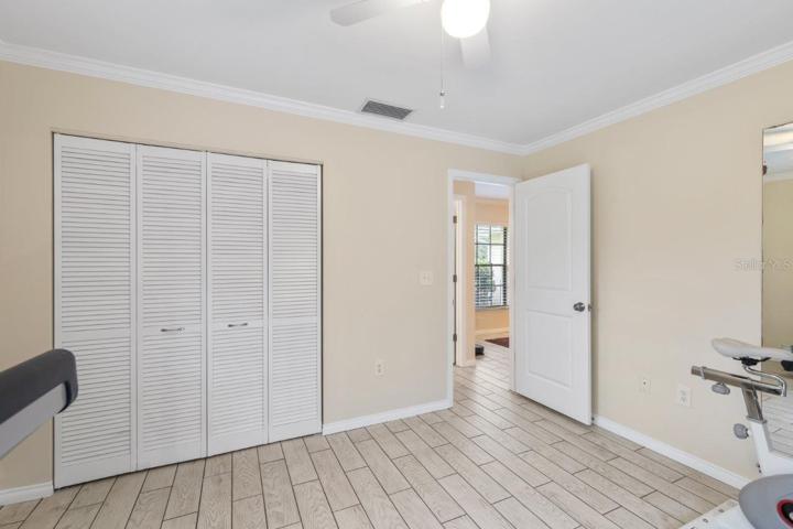 Guest bedroom #4 Featuring crown molding, and porcelain plank tile.