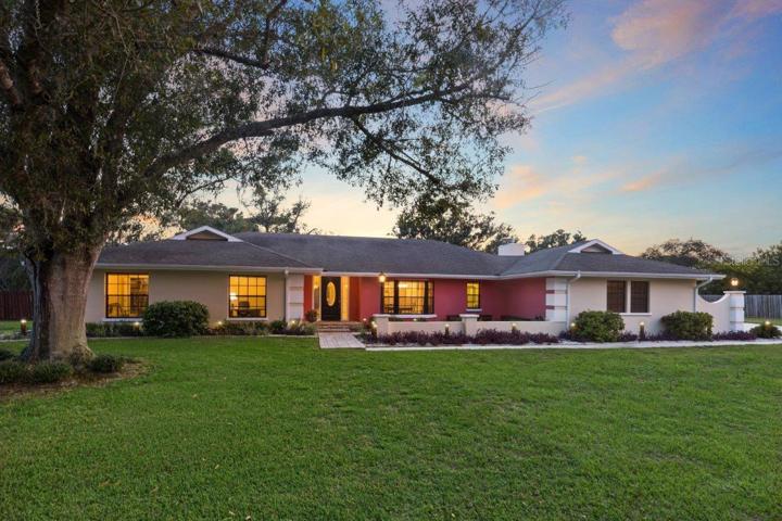Front Elevation featuring an extended front patio, custom landscape lighting, all on a spacious 1 acre lot